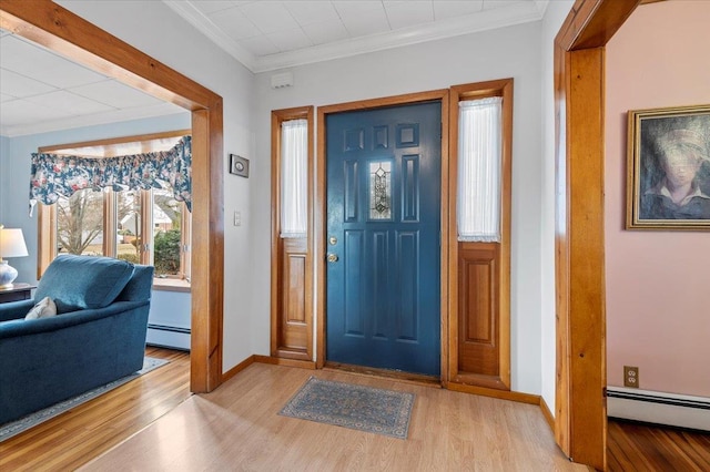 entrance foyer with light wood finished floors, baseboards, baseboard heating, and ornamental molding