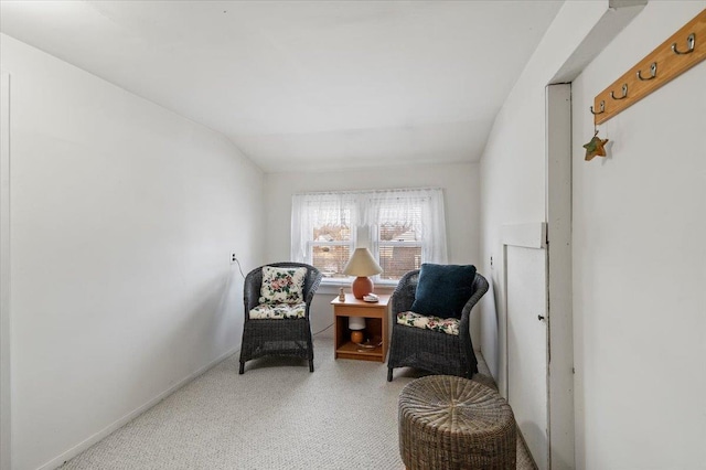 sitting room featuring lofted ceiling, carpet, and baseboards