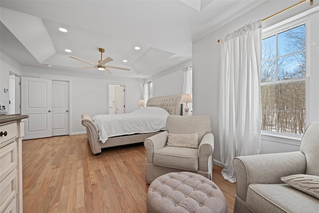 bedroom with a ceiling fan, baseboards, light wood-style flooring, recessed lighting, and a raised ceiling