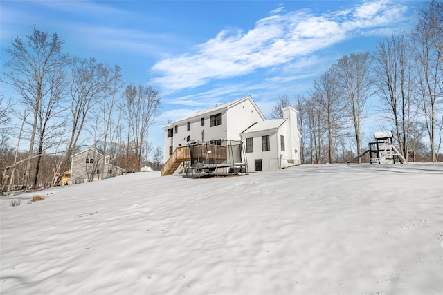 snow covered property featuring a deck, stairway, and a chimney