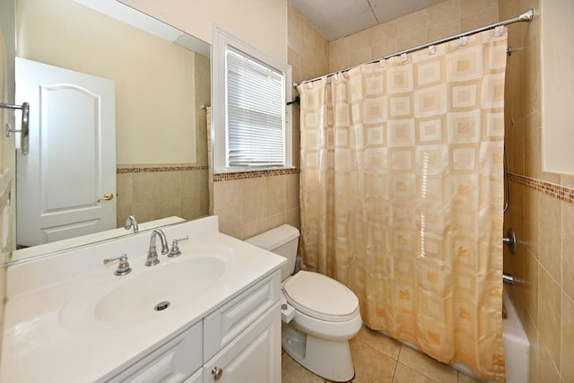 full bath featuring tile patterned flooring, vanity, tile walls, toilet, and wainscoting