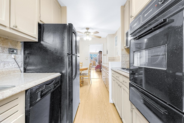 kitchen featuring tasteful backsplash, black appliances, light countertops, and light wood-style floors