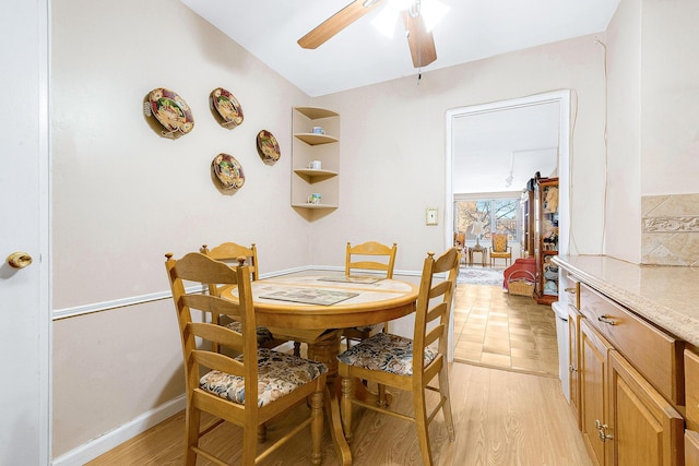 dining space with baseboards, light wood-style floors, and a ceiling fan