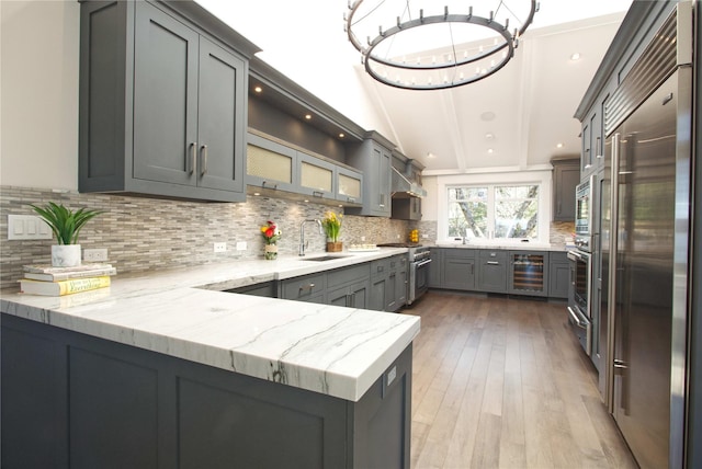 30 Half Moon Ln, Irvington, NY 10533 - kitchen featuring light stone countertops, a sink, built in appliances, wine cooler, and a warming drawer