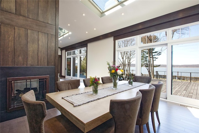 30 Half Moon Ln, Irvington, NY 10533 - dining space featuring a skylight, wood finished floors, a large fireplace, a water view, and visible vents