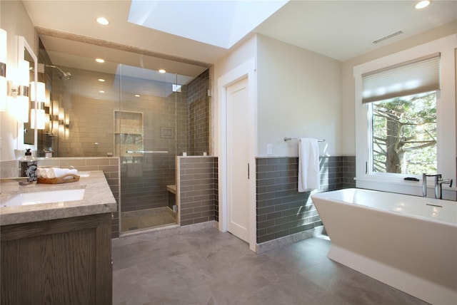 30 Half Moon Ln, Irvington, NY 10533 - full bath featuring visible vents, a stall shower, tile walls, a freestanding tub, and vanity