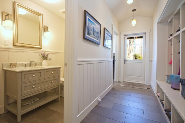 30 Half Moon Ln, Irvington, NY 10533 - mudroom with dark tile patterned floors, wainscoting, a sink, and a decorative wall