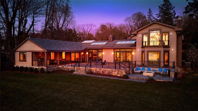 30 Half Moon Ln, Irvington, NY 10533 - back of house with outdoor lounge area, a patio area, roof mounted solar panels, a lawn, and a balcony