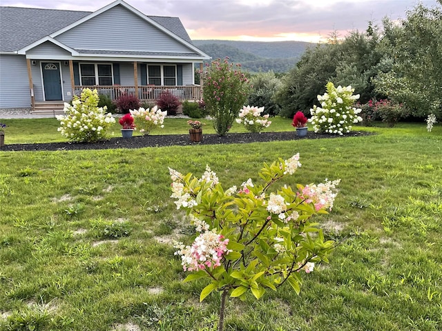 yard at dusk with a porch and a mountain view