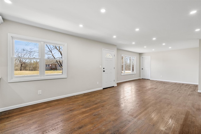 unfurnished living room with recessed lighting, baseboards, and wood finished floors