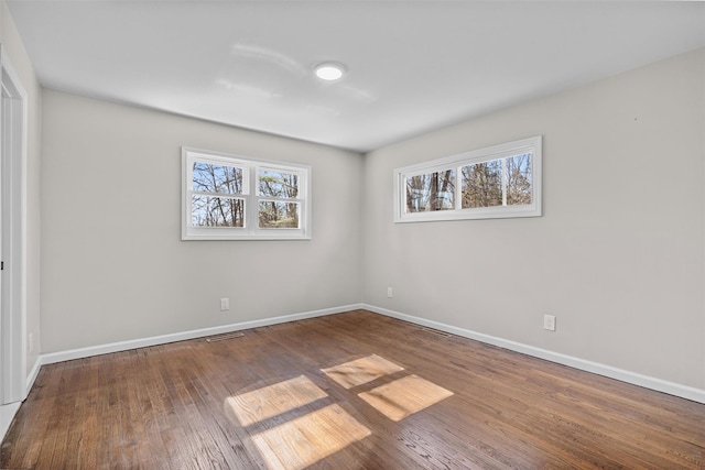 unfurnished bedroom featuring visible vents, baseboards, and wood finished floors