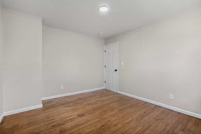 unfurnished room featuring baseboards and wood finished floors