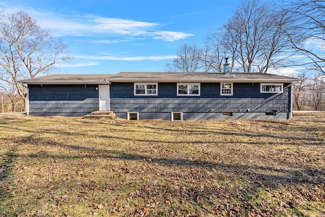 back of property with a yard and a chimney