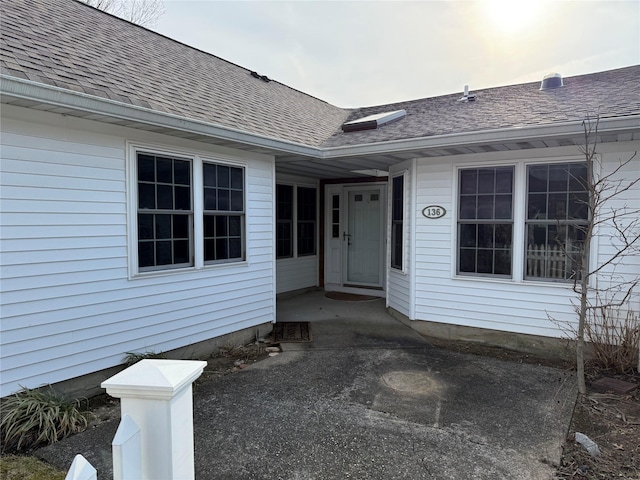 entrance to property featuring a shingled roof