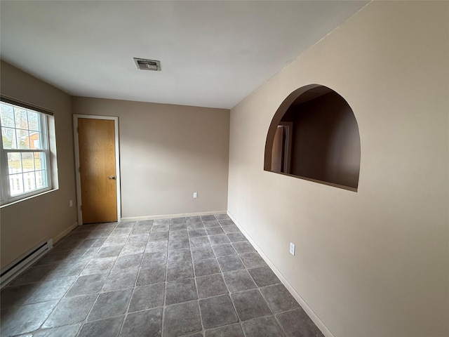 empty room with baseboards, visible vents, and baseboard heating