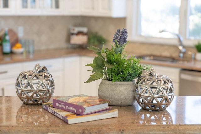 details with white cabinetry, dishwashing machine, and a sink