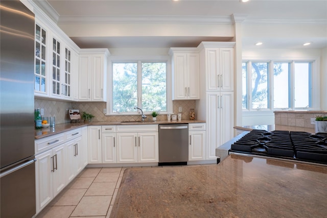 kitchen featuring stone counters, white cabinets, appliances with stainless steel finishes, and glass insert cabinets