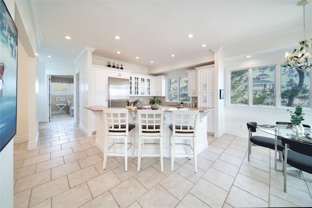 dining room with light tile patterned floors, baseboards, recessed lighting, and crown molding