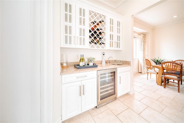 bar featuring a sink, wine cooler, crown molding, light tile patterned floors, and indoor wet bar