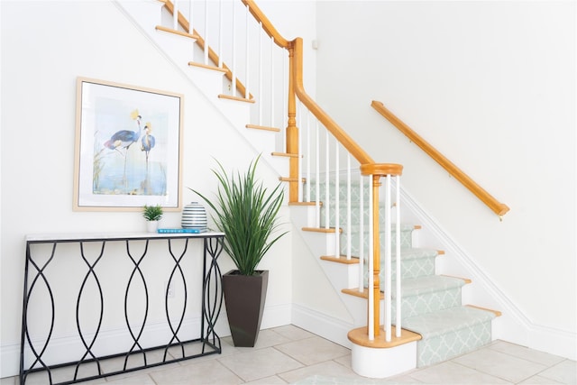 stairs featuring tile patterned floors and baseboards