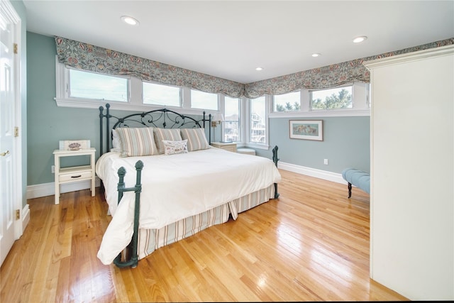 bedroom featuring recessed lighting, multiple windows, light wood-style floors, and baseboards