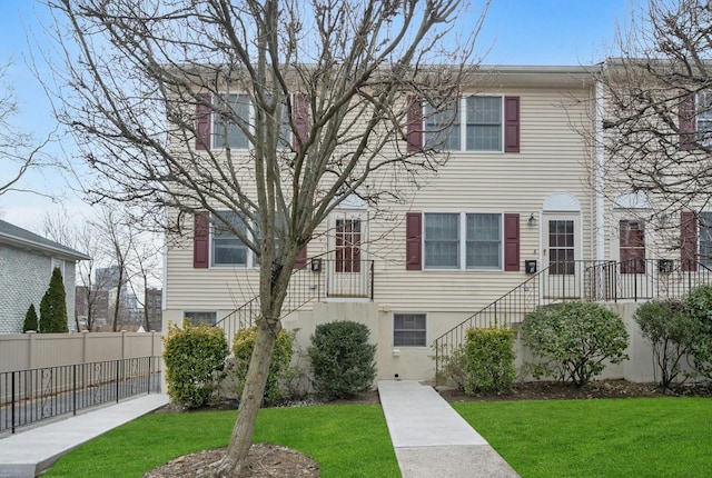 view of front of home featuring a front lawn and fence