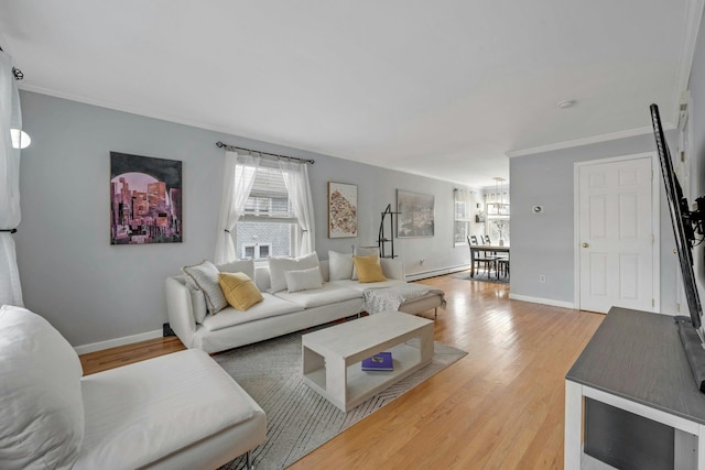 living room with baseboards, light wood-type flooring, and ornamental molding