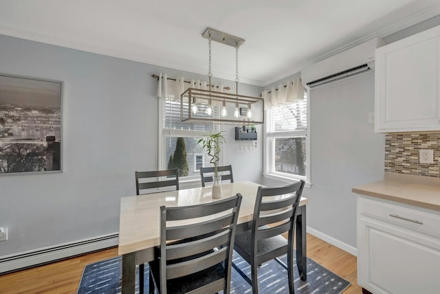 dining room with baseboards, baseboard heating, and light wood-style flooring