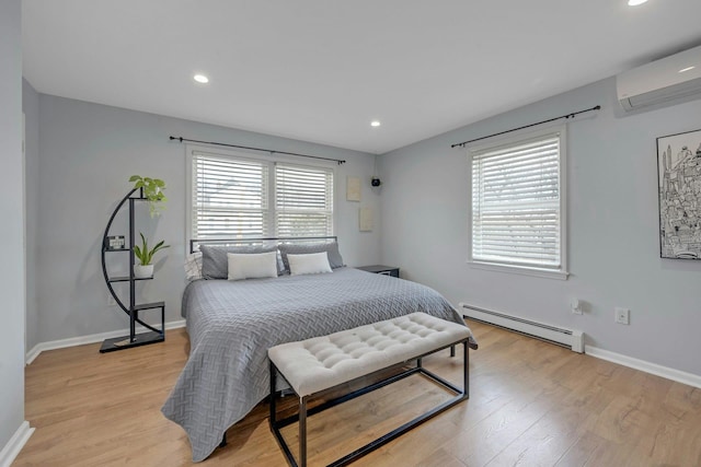 bedroom featuring light wood-style flooring, a baseboard heating unit, a wall unit AC, and multiple windows