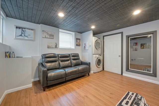 living room featuring recessed lighting, baseboards, stacked washer / drying machine, and light wood finished floors