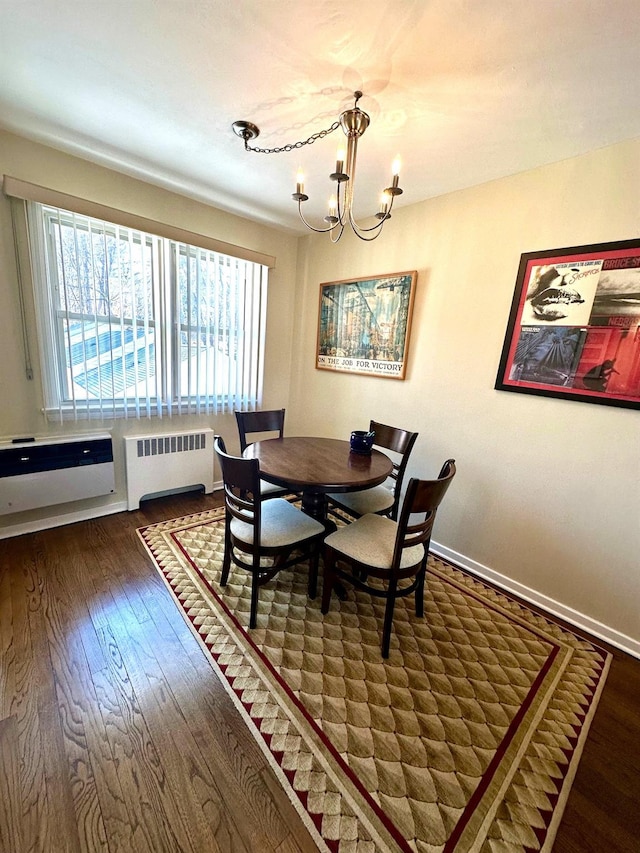 dining space with a notable chandelier, radiator, baseboards, and hardwood / wood-style floors