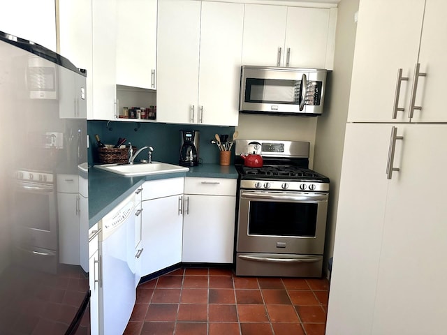 kitchen with a sink, dark tile patterned floors, white cabinets, stainless steel appliances, and open shelves