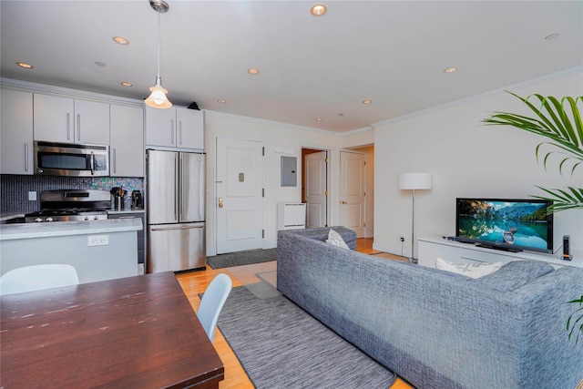 living room featuring electric panel, recessed lighting, light wood-style floors, and ornamental molding