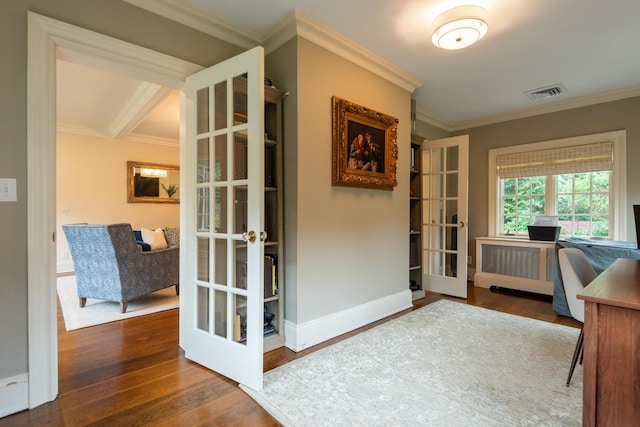 office space with visible vents, wood finished floors, french doors, radiator, and crown molding