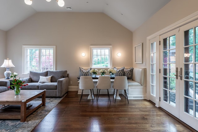 living area with visible vents, french doors, lofted ceiling, and wood finished floors