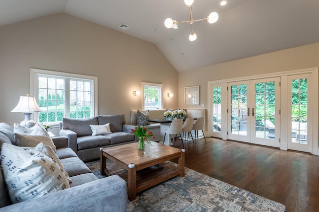 living area with wood finished floors, visible vents, french doors, and high vaulted ceiling