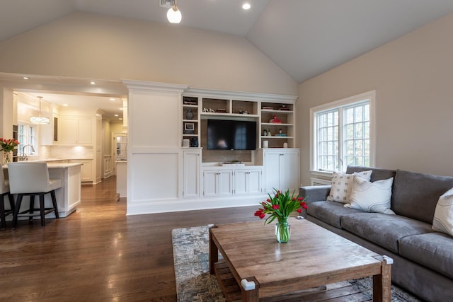 living room with dark wood finished floors, recessed lighting, and high vaulted ceiling