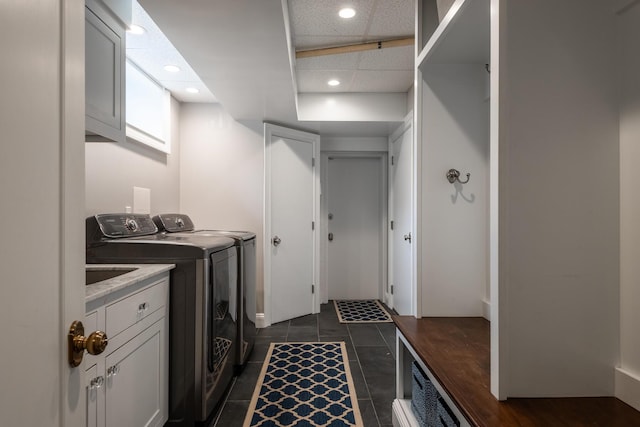 laundry area featuring cabinet space, recessed lighting, washing machine and dryer, and dark tile patterned floors