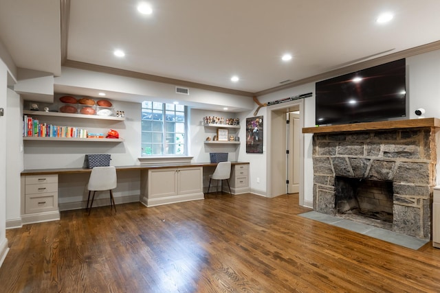 unfurnished office featuring a barn door, visible vents, wood finished floors, and built in desk