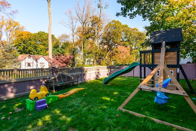 view of jungle gym with a lawn and fence