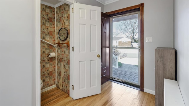 foyer entrance featuring light wood-style flooring, baseboards, and ornamental molding