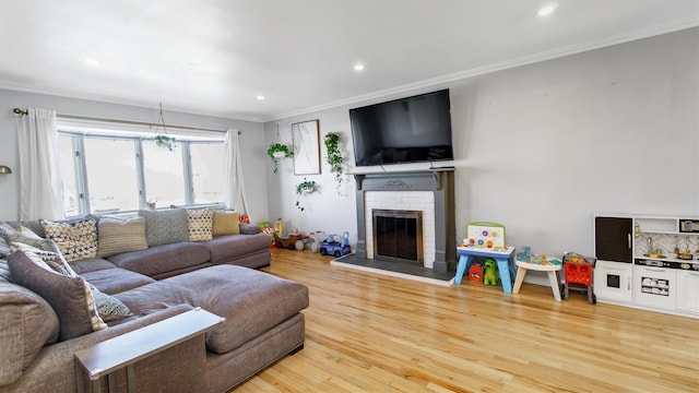 living room featuring ornamental molding, a fireplace, and wood finished floors