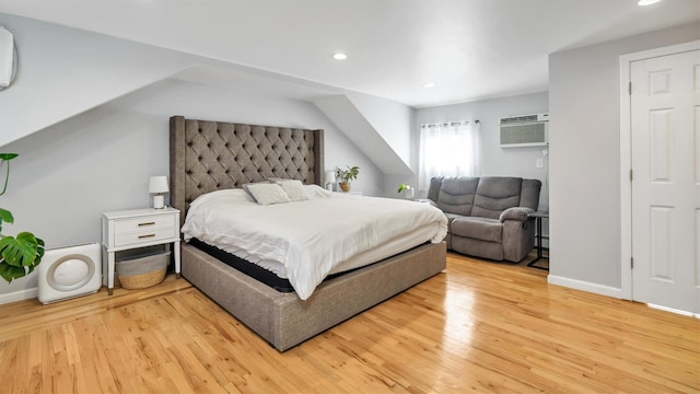 bedroom with recessed lighting, wood finished floors, baseboards, and a wall mounted AC