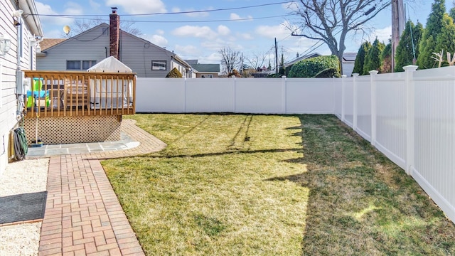 view of yard with a wooden deck and a fenced backyard