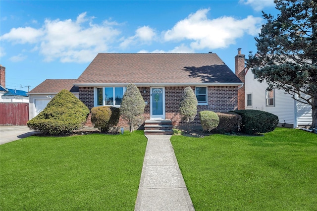 view of front of property featuring a front lawn, fence, brick siding, and roof with shingles