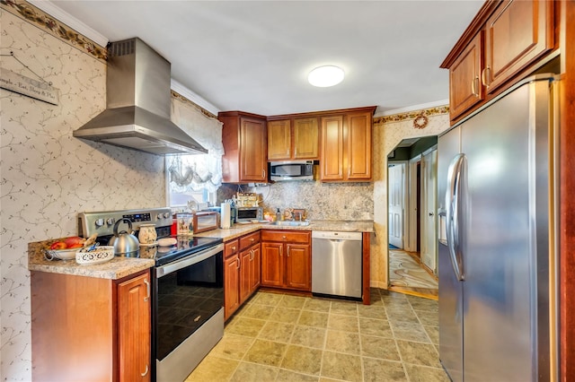 kitchen with wallpapered walls, light countertops, wall chimney range hood, and stainless steel appliances