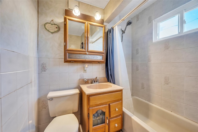 full bathroom with vanity, tile walls, toilet, and shower / tub combo with curtain