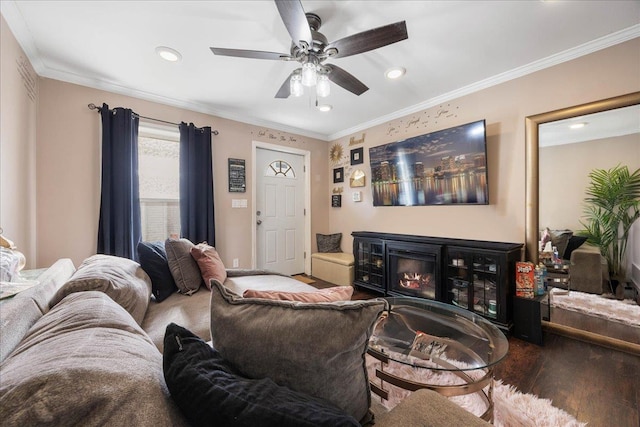 living room with a ceiling fan, wood finished floors, recessed lighting, a glass covered fireplace, and crown molding