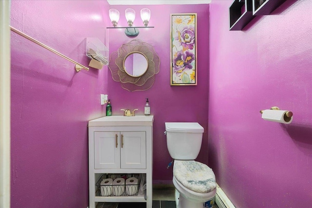 half bath featuring toilet, vanity, and a baseboard radiator