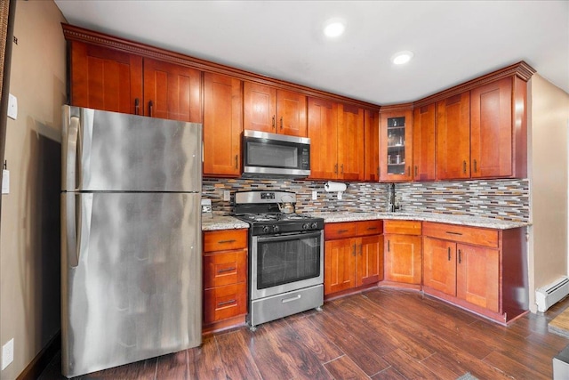 kitchen with a baseboard heating unit, light stone countertops, tasteful backsplash, and appliances with stainless steel finishes